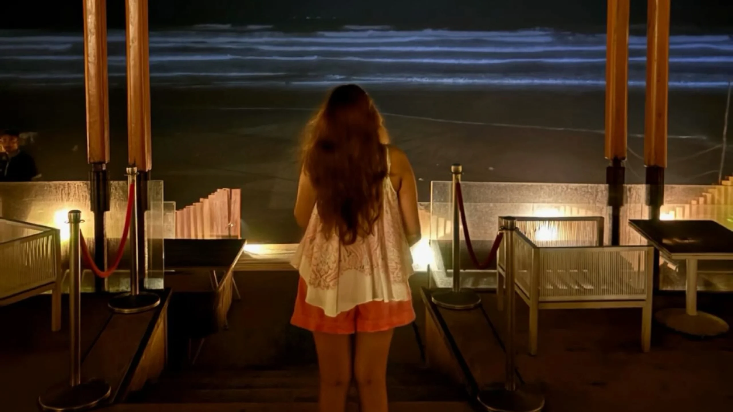 beach Teen girl gazing at the dark night sky on the beach, lost in deep thought, reflecting on unanswered emotional questions under the moonlight